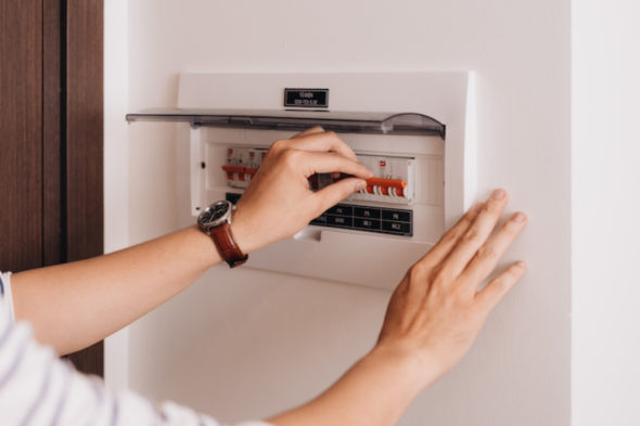 Manos tocando los mandos de un cuadro eléctrico