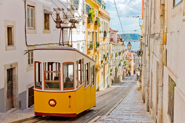 Tranvía amarillo subiendo por una de las calles inclinadas de Lisboa