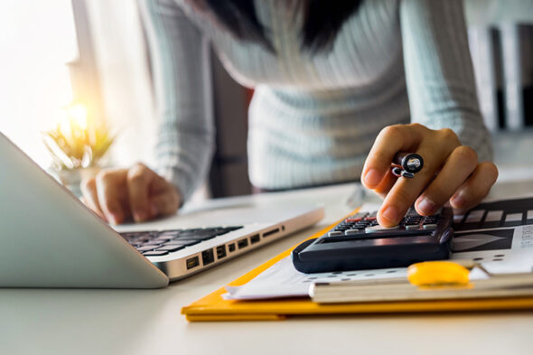 Mujer con un ordenador y una calculadora