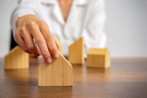 Mano sujetando una casita de madera