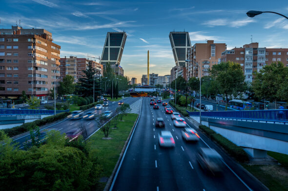 Coches pasando entre las Torres Kio de Madrid