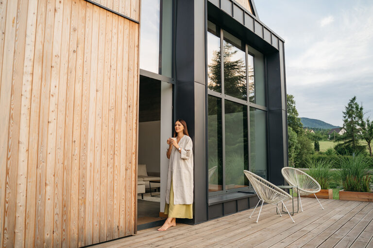 Mujer en la puerta de la terraza con sillas de diseño moderno