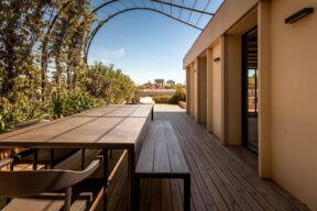 Terraza en un ático con mesa y suelo de madera