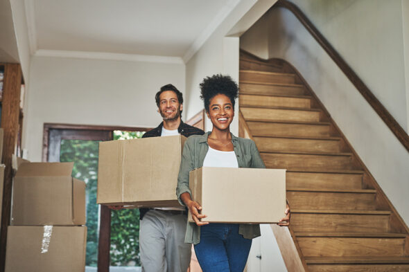 Pareja llevando cajas en su casa nueva