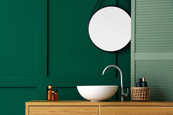 Lavabo del baño blanco sobre pared verde