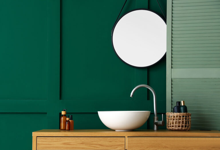 Lavabo del baño blanco sobre pared verde