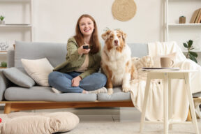 Mujer con un perro viendo la televisión