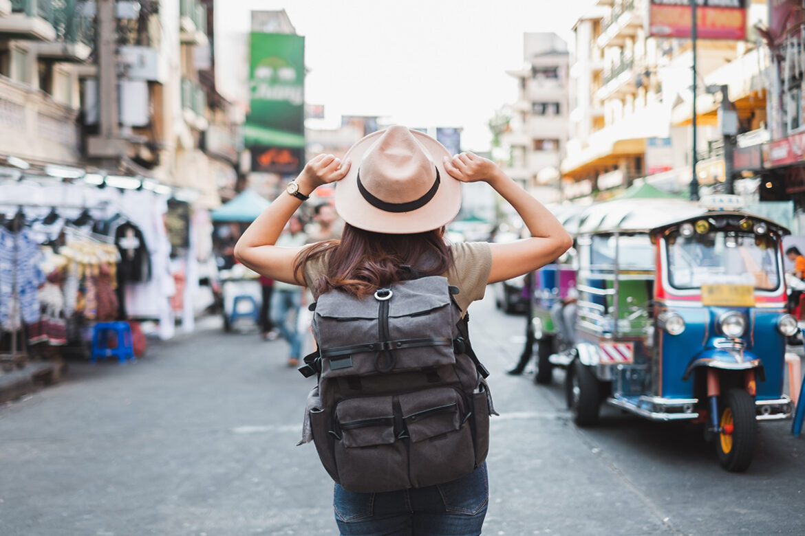 Mujer de vacaciones en noviembre, con mochila y sombrero